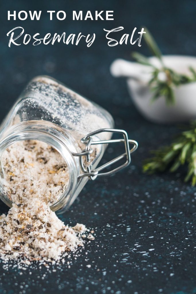 small glass jar of rosemary salt tipped over on a dark surface with text overlay 'how to make rosemary salt'