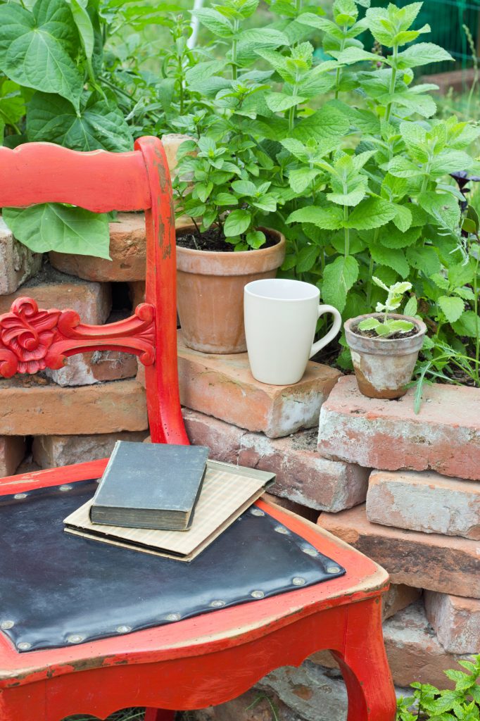 books on a chair in an outdoor herb garden